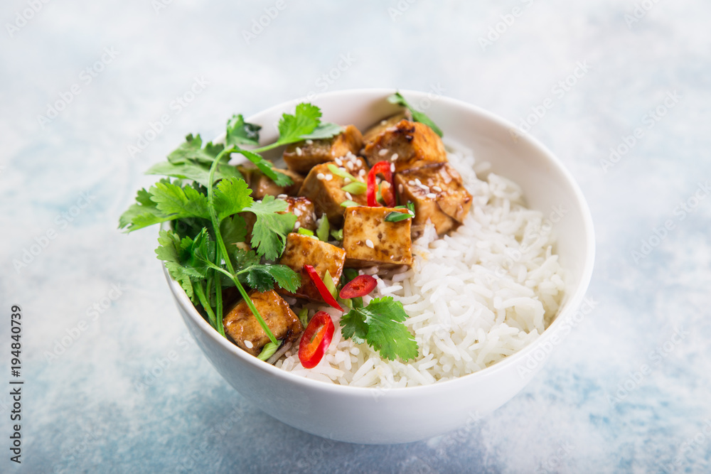 bowl of teriyaki tofu cheese and rice served with lime, cilantro and sesame seeds bowl of teriyaki tofu cheese and rice served with lime, cilantro and sesame seeds