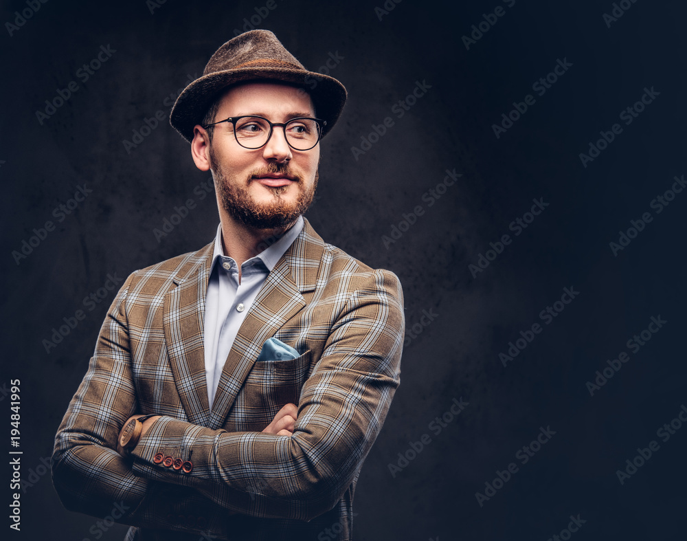 Studio portrait of a bearded hipster in hat and glasses wearing Studio portrait of a bearded hipster in hat and glasses wearing