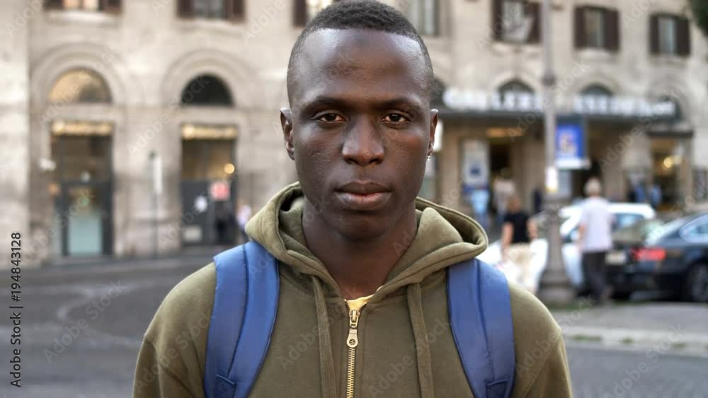 young black american student staring at camera in the street young black american student staring at camera in the street