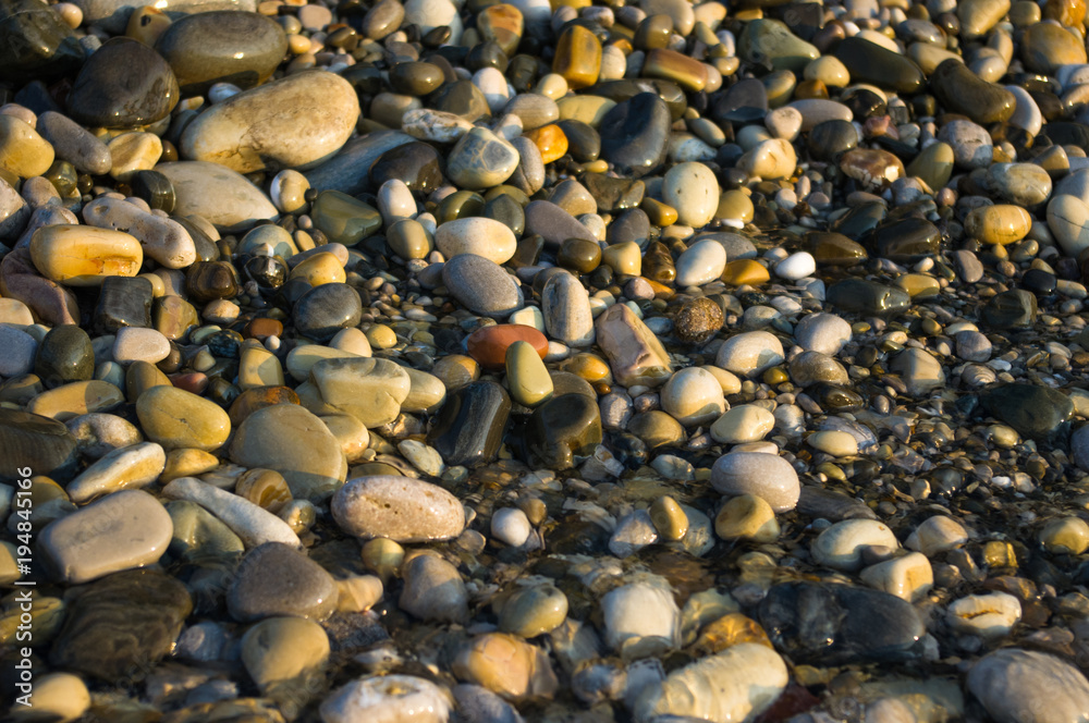 pebble stones on the sea beach, the rolling waves of the sea with foam pebble stones on the sea beach, the rolling waves of the sea with foam
