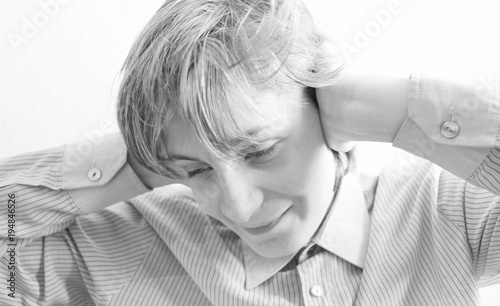 Boy teenager closes his ears with his hands photo