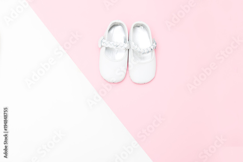 Shoes for babe on a white and pink background. Copy space