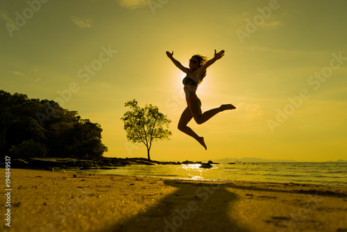 woman jumping on the tropical beach in Thailand