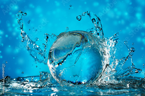 water wave splashing on a transparent ball in a blue background