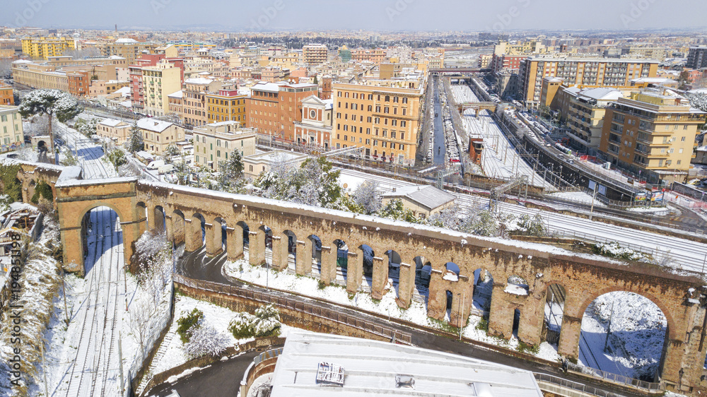  Aerial view of railroad section covered by snow. The tracks and rails are submerged by snow falling in Rome during the cold winter. The movement of metropolitan trains is blocked.