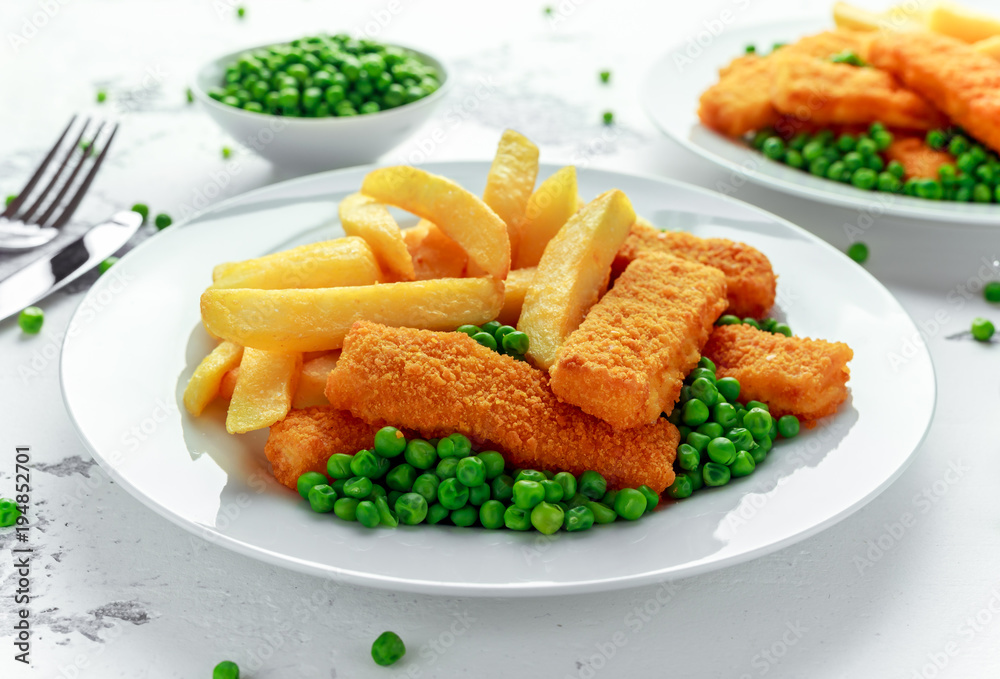 British Traditional Fish finger and chips with peas and tartar sauce in a white plate. British Traditional Fish finger and chips with peas and tartar sauce in a white plate.