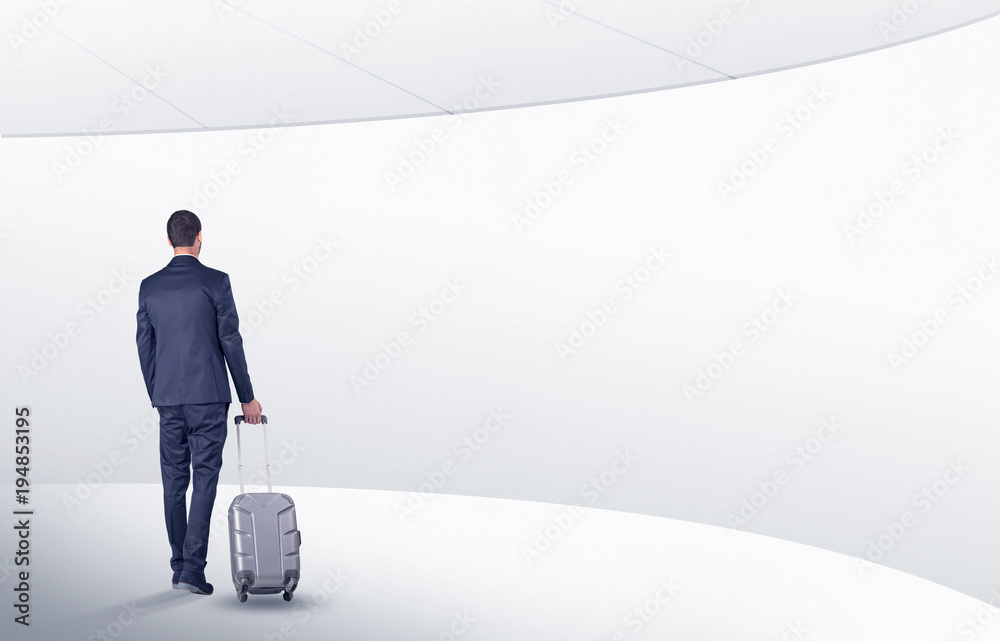Businessman with suitcase walking in waiting room Businessman with suitcase walking in waiting room