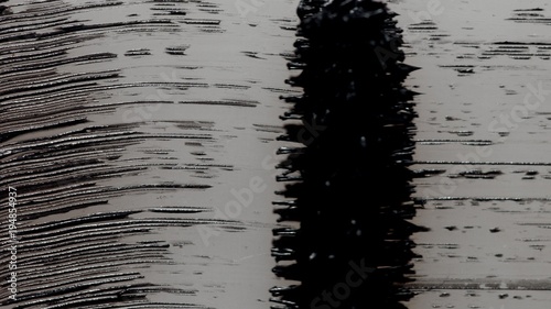 Black mascara brush strokes on white macro texture photo
