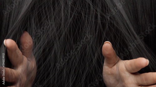 Hair texture background, no person. Black shiny hair Hands touching it
