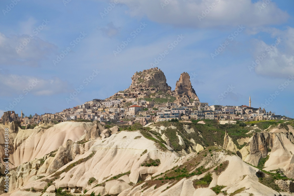 Wide angle of Uchisar city on the hill at daytime with cloudy blue sky in Cappadocia, Turkey