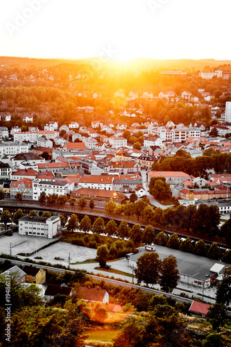 Sun setting over a traditional Norwegian neighborhood. View over a beautiful city in Norway with many houses and streets during sunset. photo