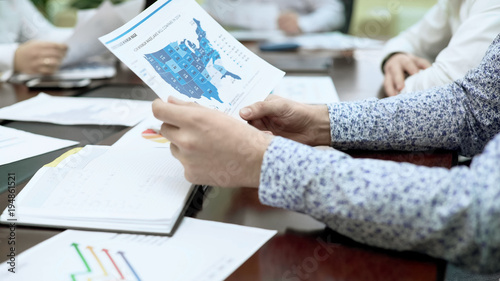 Canvas-taulu PR manager checking report document in business meeting, regional statistics