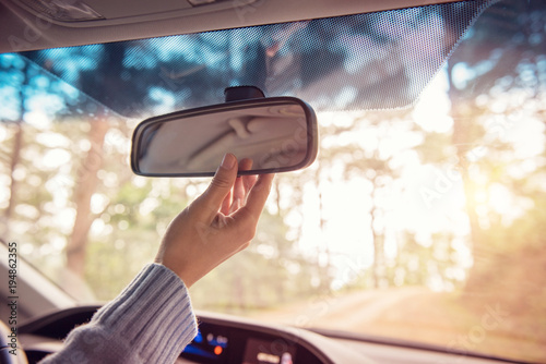 Fotografía Close up Hand adjusting rear view mirror. Safety concept.
