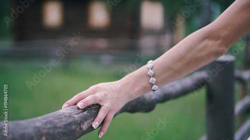 Close-up of bride's hands with on beautiful white wedding dress. Clip. Newlywed girl in outdoor near wooden fence © Media Whale Stock