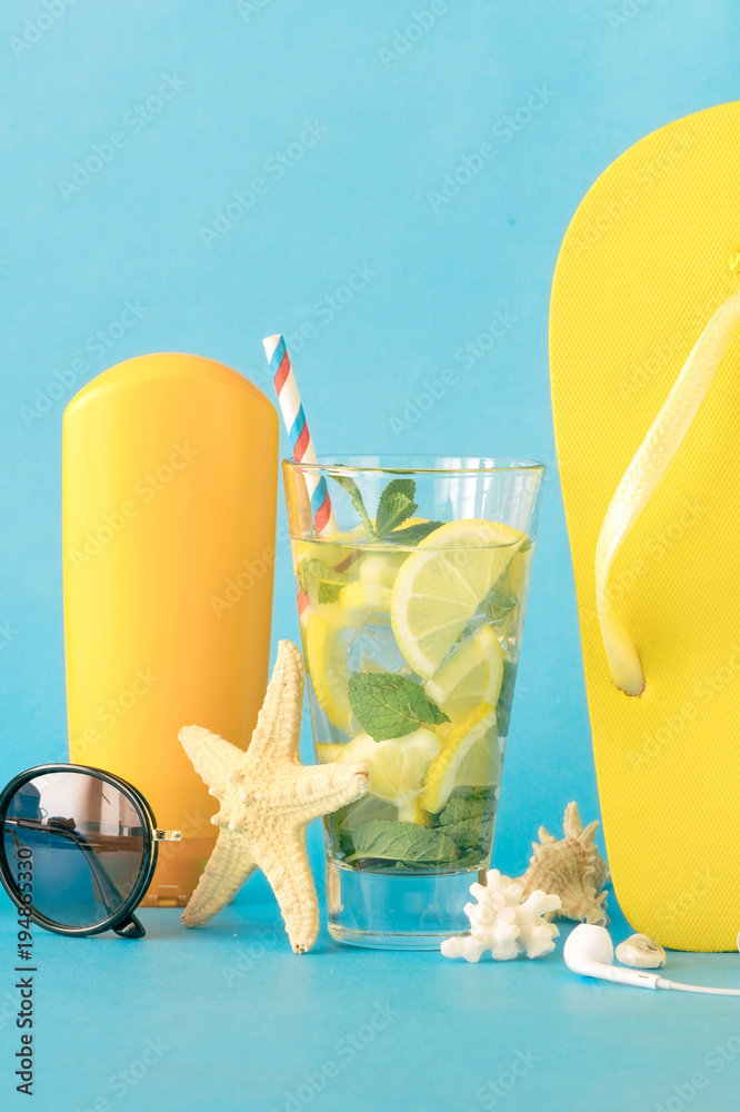 Summer background. Summer refreshing cocktail  with beach accessories on blue background