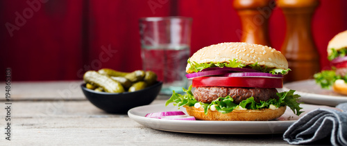 Burger on a plate. Wooden background. Copy space.
