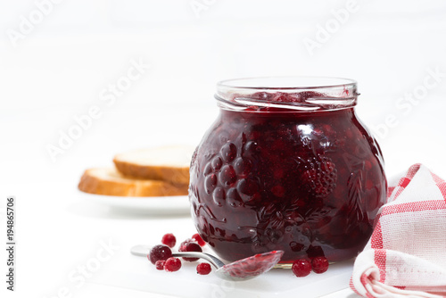 jar of cranberry jam on a white table, closeup