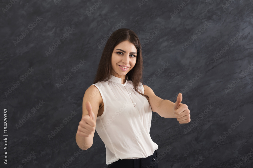 Happy young woman showing thumb up gesture