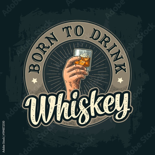 Male hand holding a glass with whiskey and ice cubes