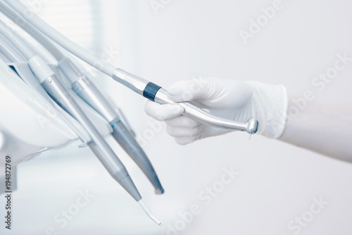 Stomatological instrument in dentists clinic. Doctor dentist takes hand instrument photo