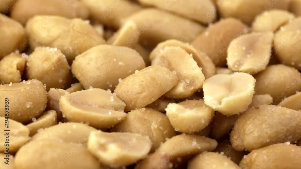 Roasted salted peanuts closeup macro revolving on a turntable. Low angle with shallow depth of field. Not loopable. Colors out of camera. No color grading. Roasted salted peanuts closeup macro revolving on a turntable. Low angle with shallow depth of field. Not loopable. Colors out of camera. No color grading.