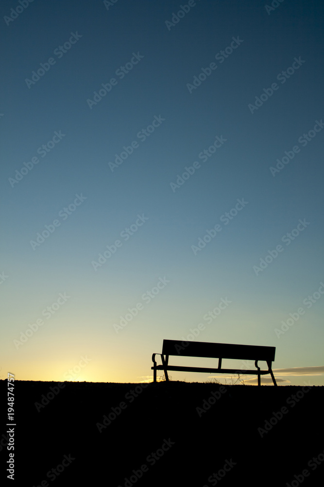 Silhouette chair on Sunset background.