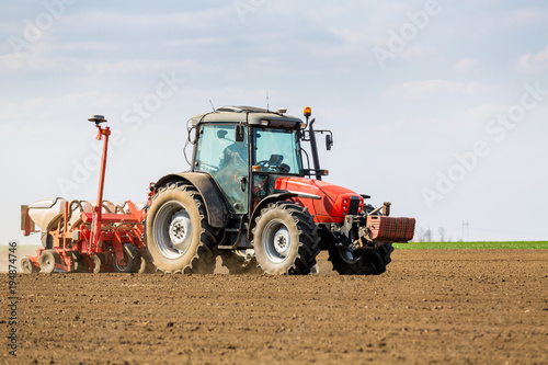 Farmer seeding  sowing crops at field. Sowing is the process of planting seeds in the ground as part of the early spring time agricultural activities.