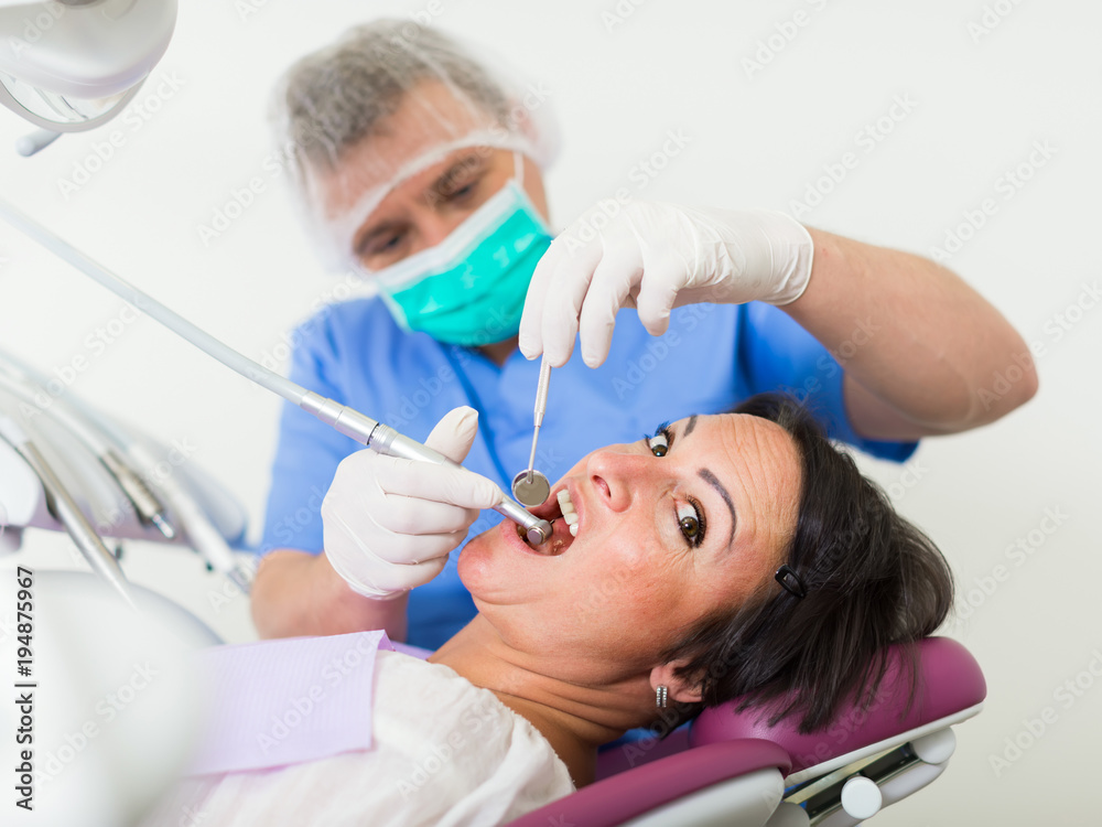 Fototapeta premium adult dentist checking teeth