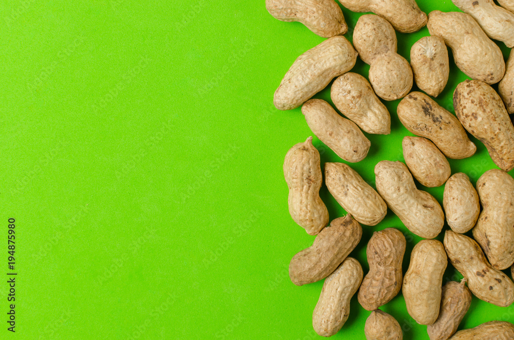 Obraz premium Peanuts on a bright green background.