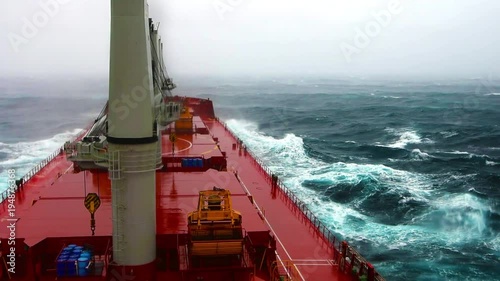 Cargo ship sailing through violent storm. Wind speed 11 as per Beaufort scale. Very large patches of foam, driven before the wind, cover much of the sea surface. Oct, 2017. Pacific, Japanese coast