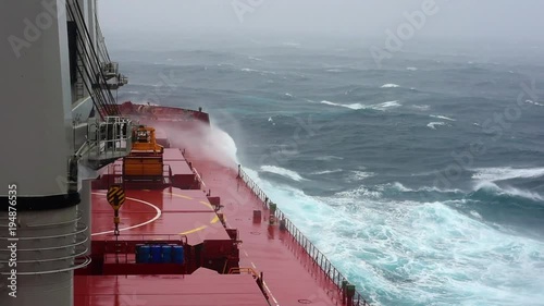 Cargo ship sailing through violent storm. Wind speed 11 as per Beaufort scale. Very large patches of foam, driven before the wind, cover much of the sea surface. Oct, 2017. Pacific, Japanese coast