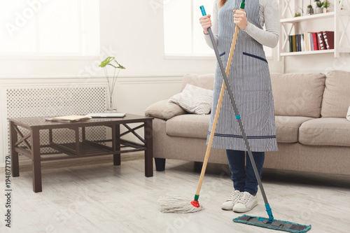 Unrecognizable woman cleaning house with mops