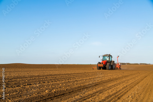 Farmer seeding, sowing crops at field. Sowing is the process of planting seeds in the ground as part of the early spring time agricultural activities. © oticki