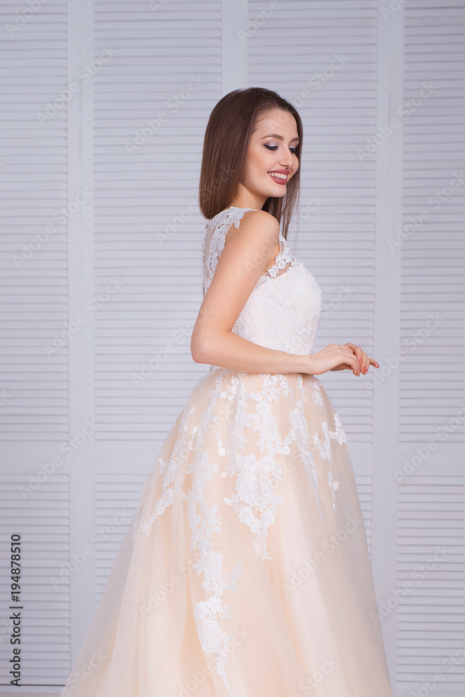 Beauty brunette model woman in evening dress. Beautiful fashion luxury makeup and hairstyle. Seductive girl silhouette in classic interior.