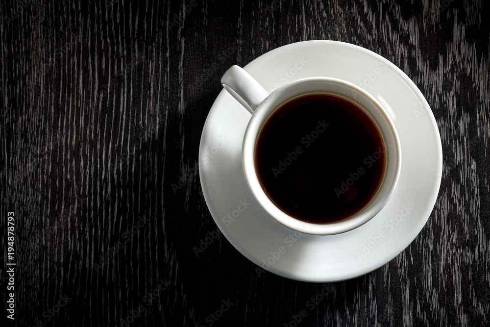 White Cup of black hot coffee on dark wooden background White Cup of black hot coffee on dark wooden background