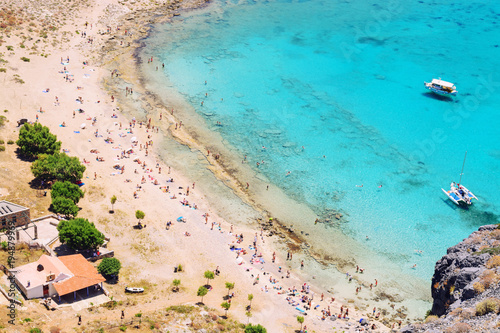 Top view of the crowded beach with white sand and turquoise sea. A popular haven for tourists.