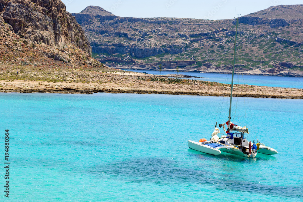 white sailing catamaran is anchored in the azure Harbor in the windless, without people