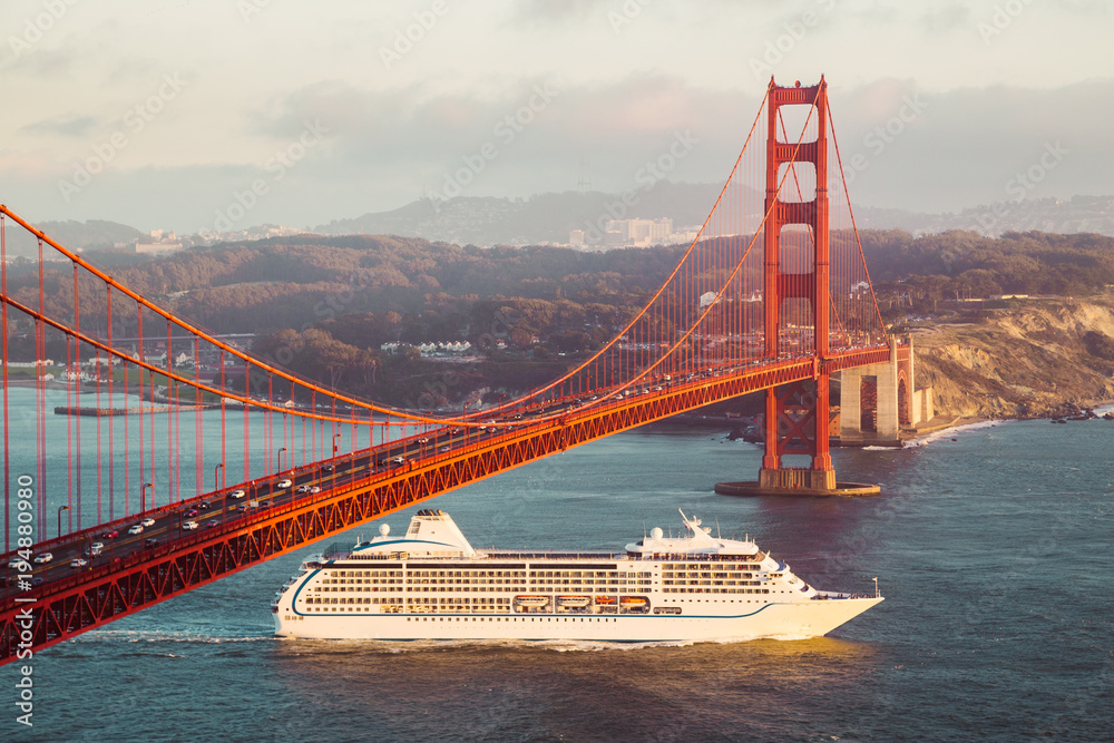 Golden Gate Bridge with cruise ship at sunset, San Francisco, California, USA