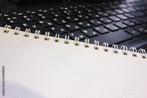Creative concept with white notebook and black laptop with space for copy or text
