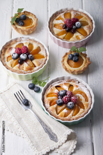 Tarts with curd cream, apricot and berries in ceramic form