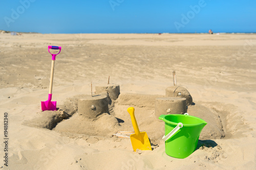 Sand castle with toys at the beach photo