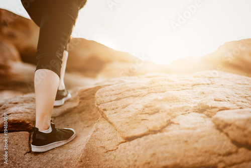 woman legs climbing to mountain peak photo