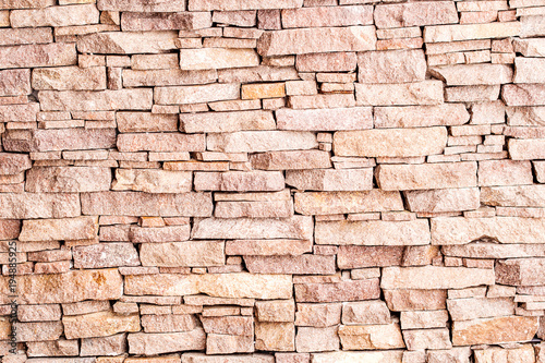 textured background made of light red stones wall