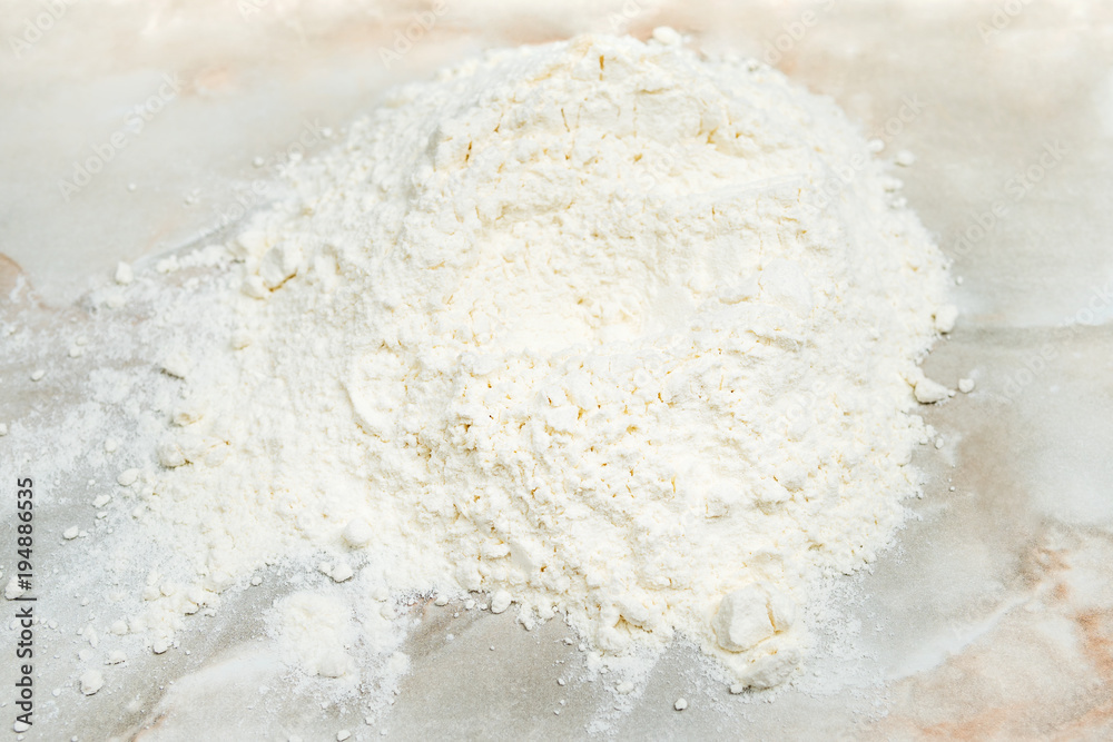 Pile of white wheat flour on a marble table Pile of white wheat flour on a marble table