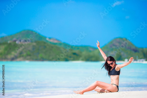 Young beautiful woman having fun on tropical seashore. Happy girl on white sand tropical beach © travnikovstudio
