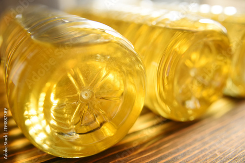 plastic bottles with sunflower oil on a wooden background close-up