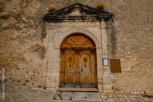 La porte sculptée en bois d'ancienne église en Provence, village de Simiane-la-Rotonte. France.