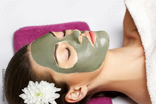 Woman with clay facial mask in beauty spa. Skincare. Beauty Conc