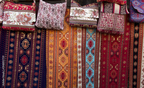colorful fabrics and other folk products at a roadside stall with traditional Armenian colors and patterns