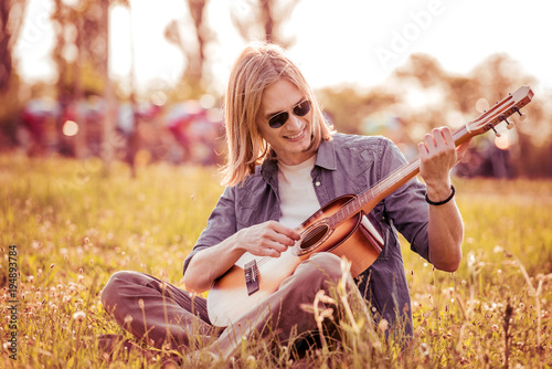 Young guy playing guitar outdoors